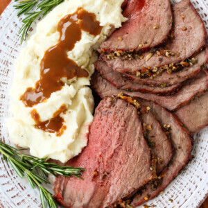 sliced roast beef on a platter with mashed potatoes