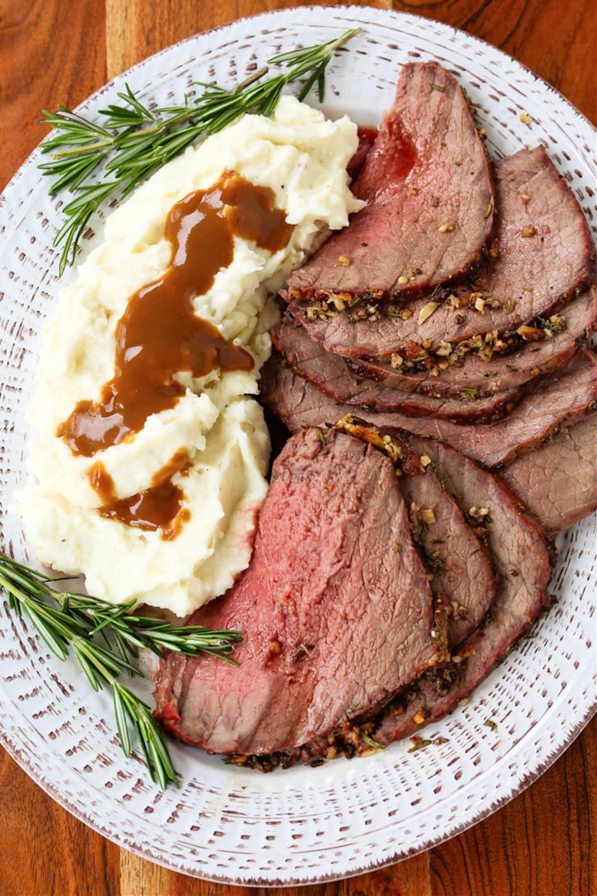 sliced roast beef on a platter with mashed potatoes