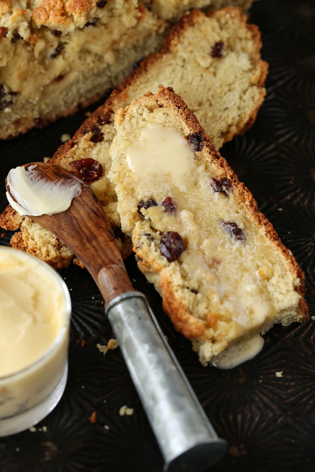 We love our slightly sweeter version of this classic Irish Soda Bread! Perfect for your St. Patrick's Day celebration, or as a homemade gift! Sliced soda bread with raisins and butter