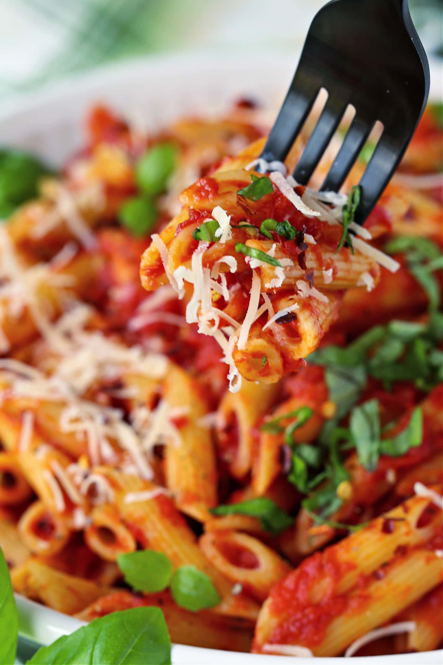 fork with bite of penne and parmesan cheese