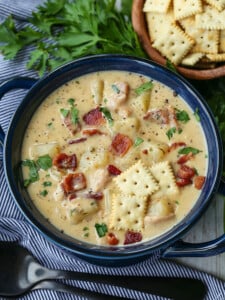 clam chowder in a blue bowl with crackers