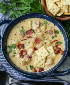 clam chowder in a blue bowl with crackers