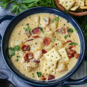 clam chowder in a blue bowl with crackers