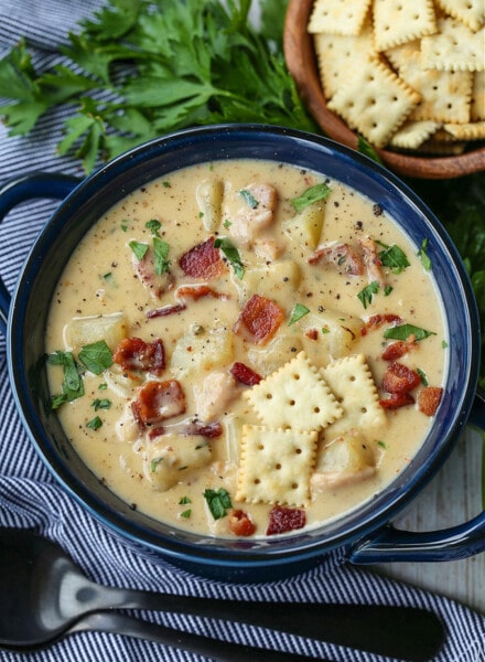 clam chowder in a blue bowl with crackers