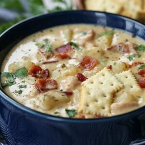 Creamy chowder recipe in a bowl with bacon and crackers
