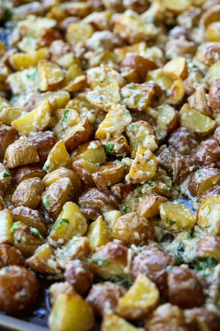 Garlic Parmesan Potatoes are a mega addicting potato side dish! Crispy, roasted potatoes tossed in our famous garlic parmesan sauce! Garlic Parmesan Potatoes tossed in sauce