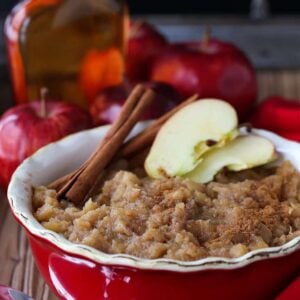 Homemade applesauce in a dish with cinnamon sticks