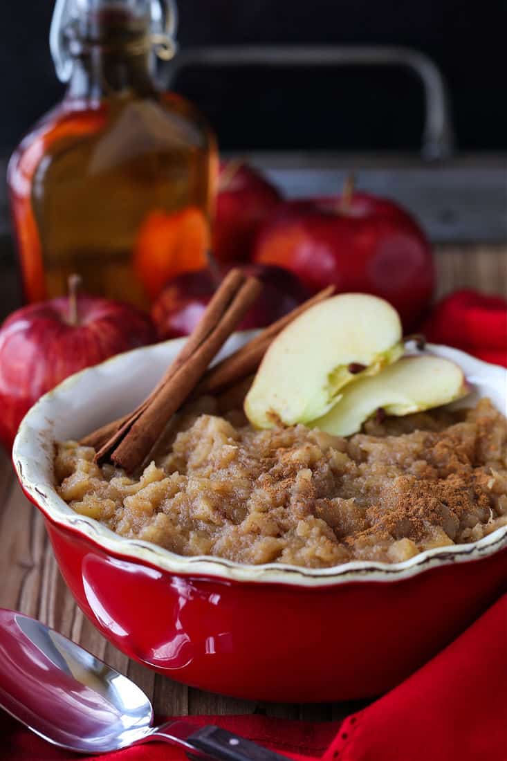 Homemade applesauce in a dish with cinnamon sticks