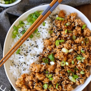 sesame ground chicken in a bowl with rice and chopsticks