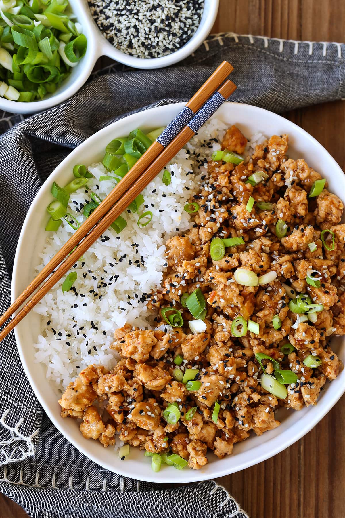 sesame ground chicken in a bowl with rice and chopsticks
