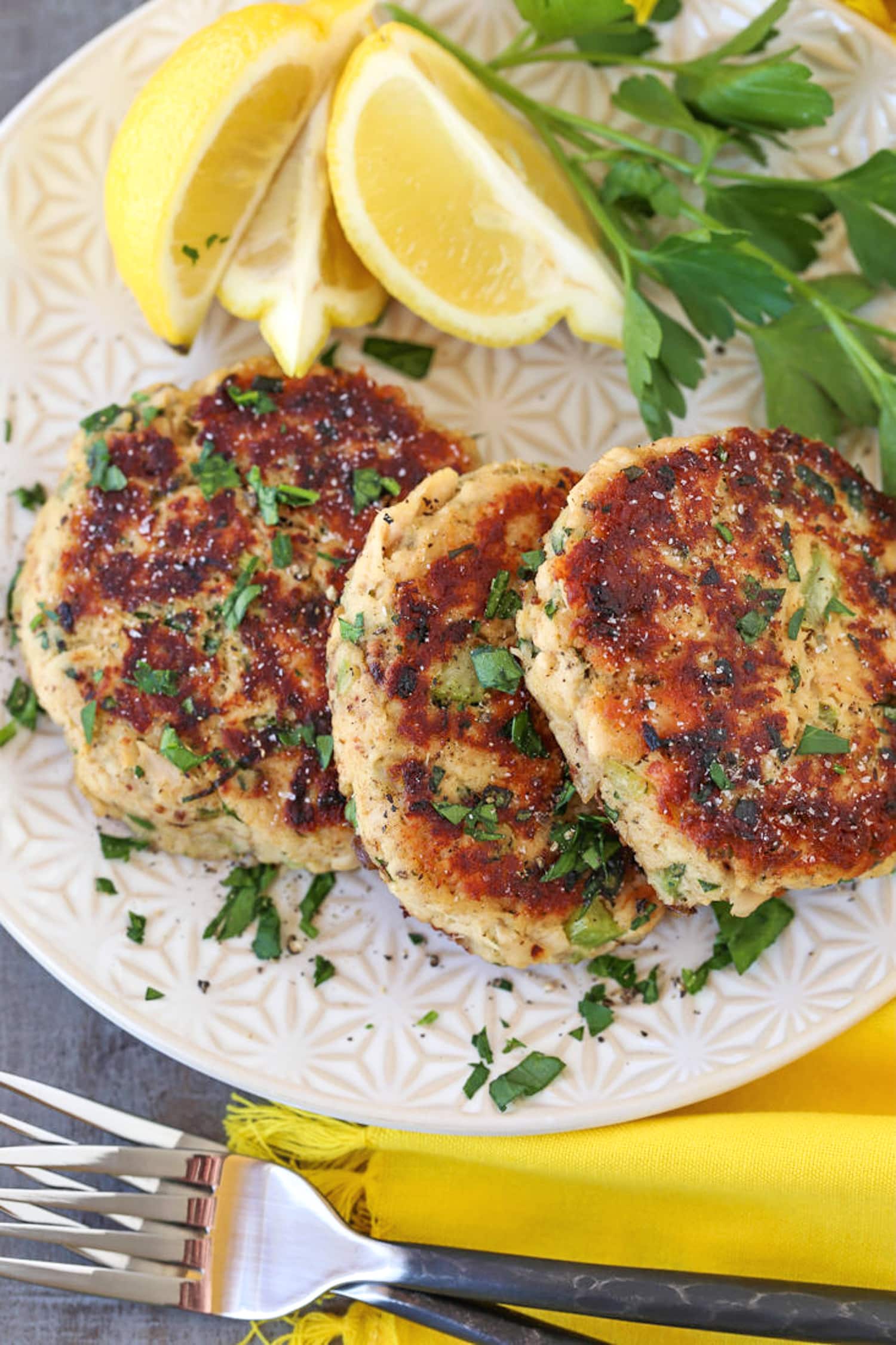 tuna cakes on a plate with lemons