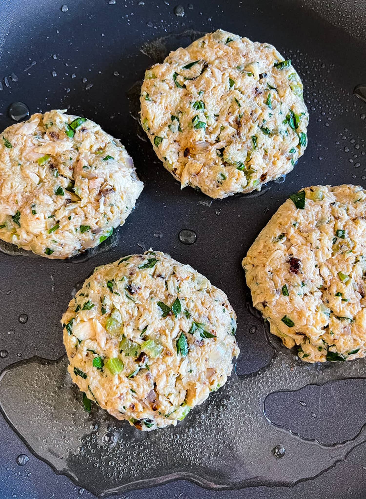 uncooked tuna cakes in skillet with oil