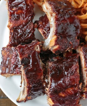 bbq ribs stacked on a plate with fries