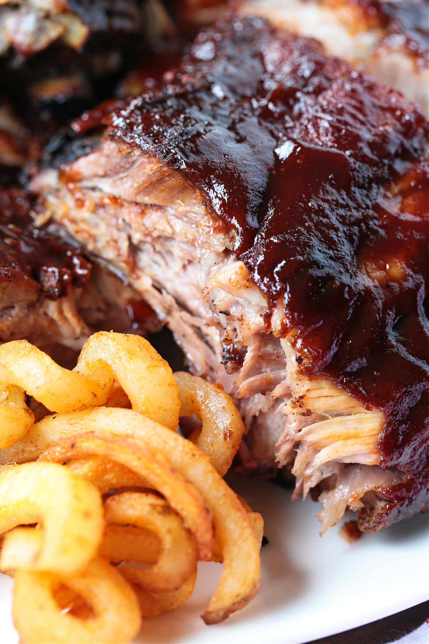 barbecue ribs on plate with curly fries