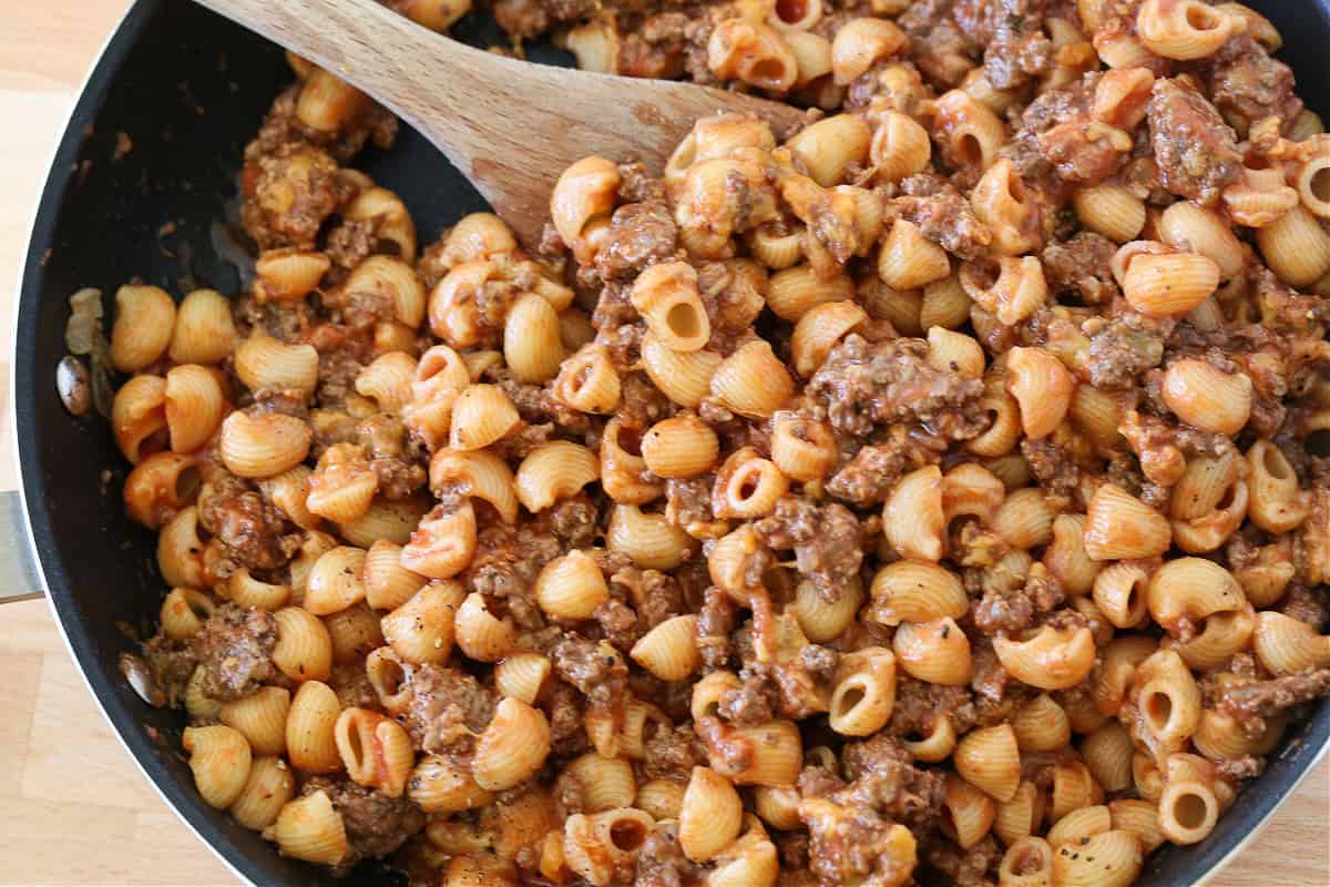 Get ready to dive into this creamy, beefy, cheesy Cheeseburger Pasta! The ultimate comfort food dinner that's ready in under 30 minutes! pasta mixed with sauce, ground beef and cheese in a skillet