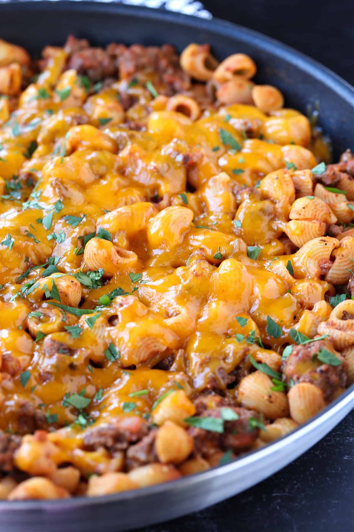 Get ready to dive into this creamy, beefy, cheesy Cheeseburger Pasta! The ultimate comfort food dinner that's ready in under 30 minutes! pasta with ground beef topped with cheese in skillet