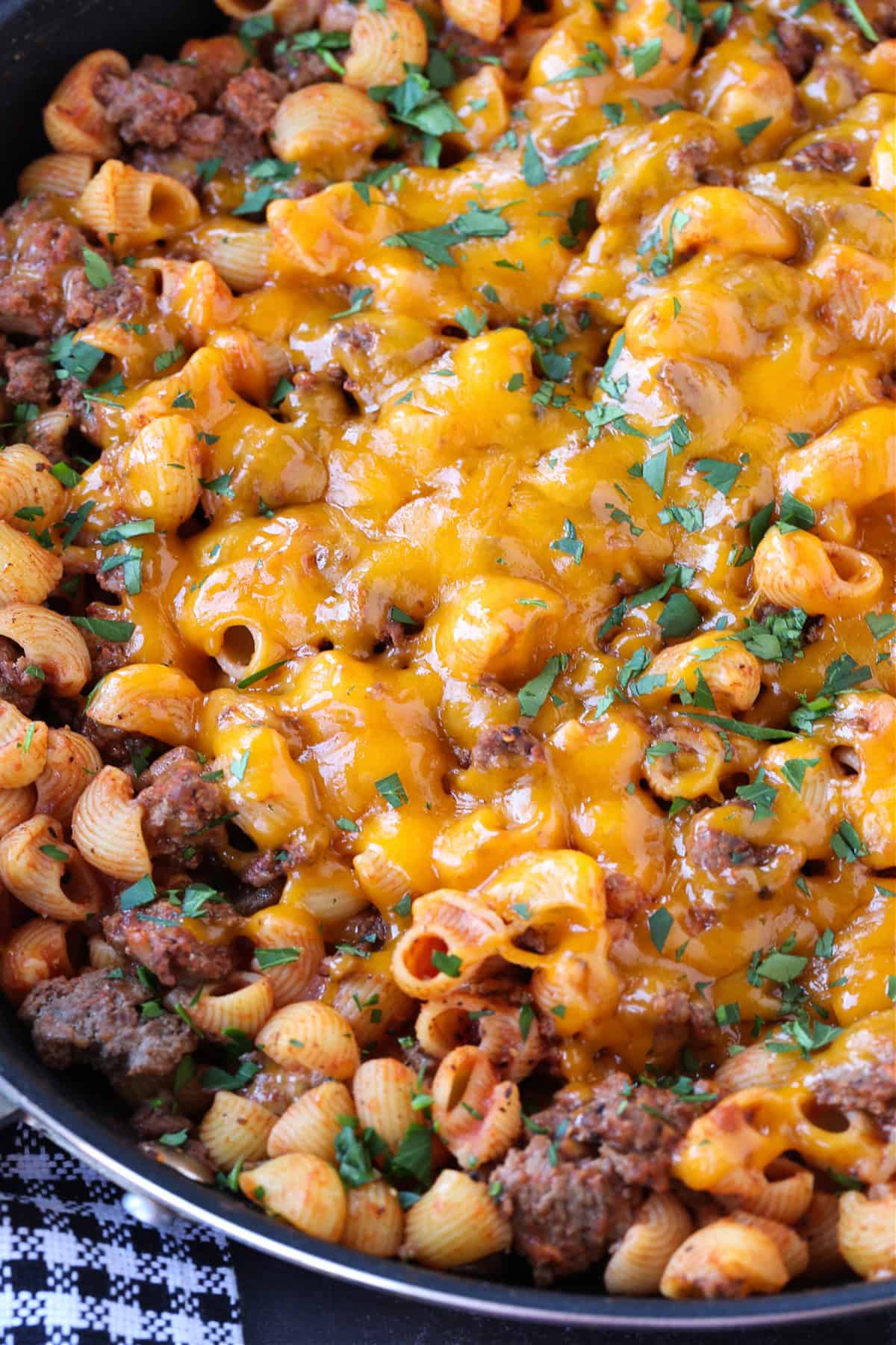 Get ready to dive into this creamy, beefy, cheesy Cheeseburger Pasta! The ultimate comfort food dinner that's ready in under 30 minutes! pasta and ground beef dinner topped with cheddar cheese in skillet