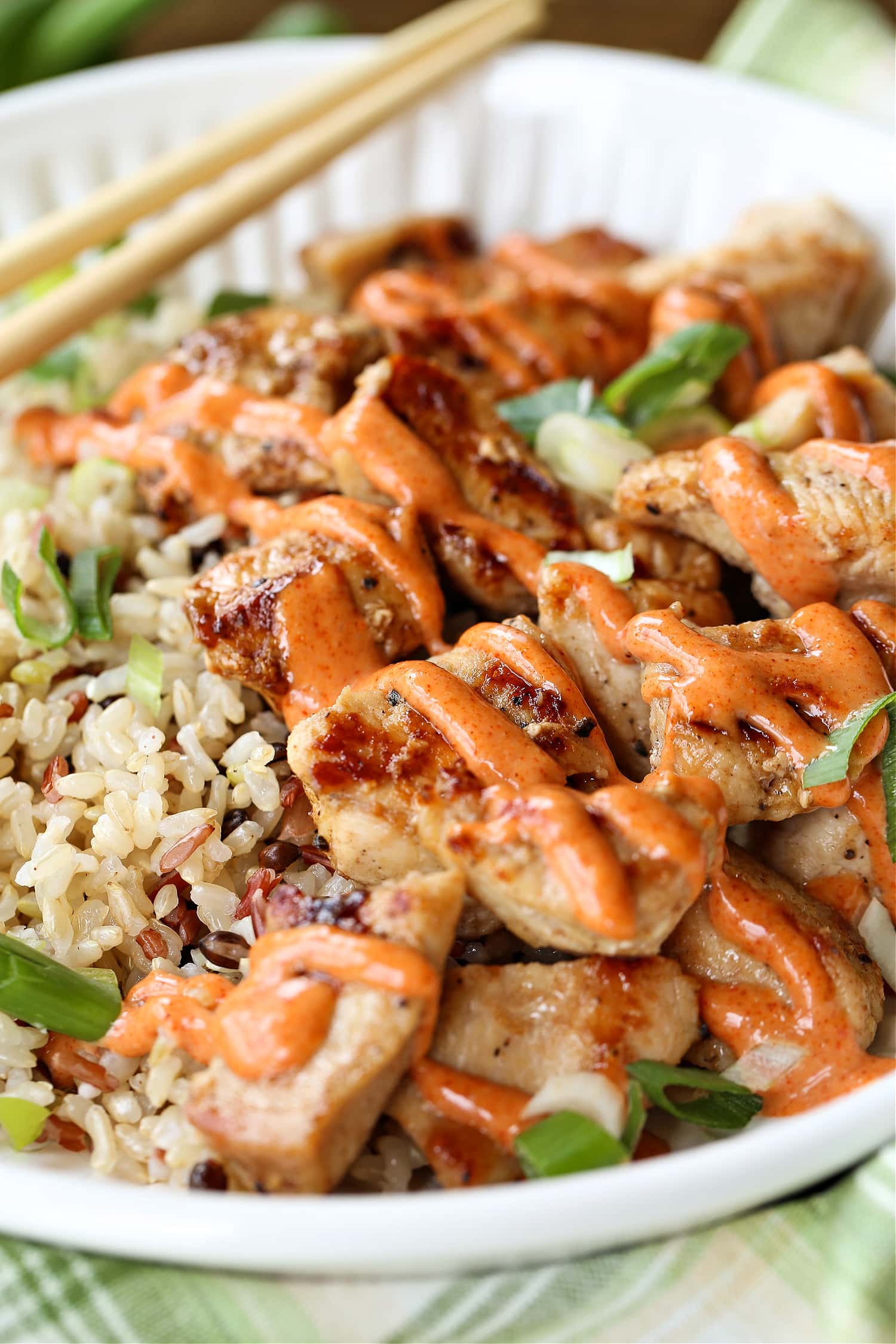 Have a fun dinner night at home with this Hibachi Chicken recipe! This chicken is so addicting you won't be able to stop eating it! diced chicken drizzled with sauce on a plate with rice