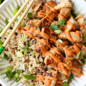 diced chicken on a plate with yum yum sauce and chop sticks