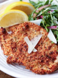 turkey cutlet on plate with salad and lemons