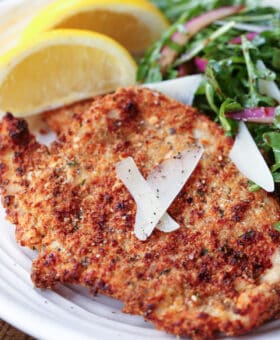 turkey cutlet on plate with salad and lemons