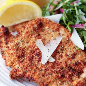 turkey cutlet on plate with salad and lemons