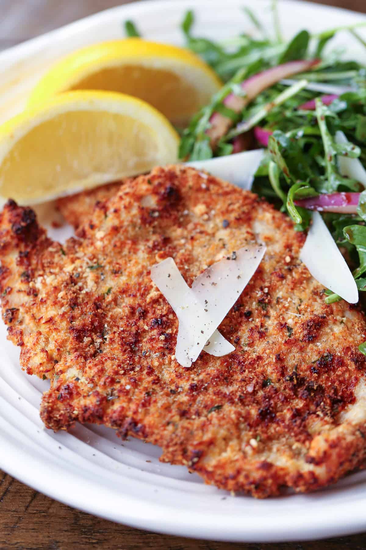 Turkey Cutlets made three ways! Oven bake, pan fry or in the air fryer, they turn out super crispy and tasty any way you make them! turkey cutlet on plate with salad and lemons