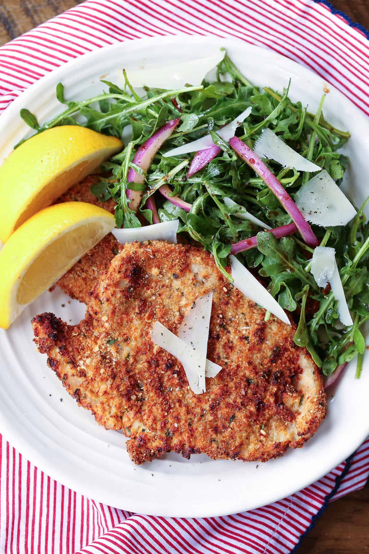 Turkey Cutlets made three ways! Oven bake, pan fry or in the air fryer, they turn out super crispy and tasty any way you make them! turkey cutlet on a plate with salad and lemon slices