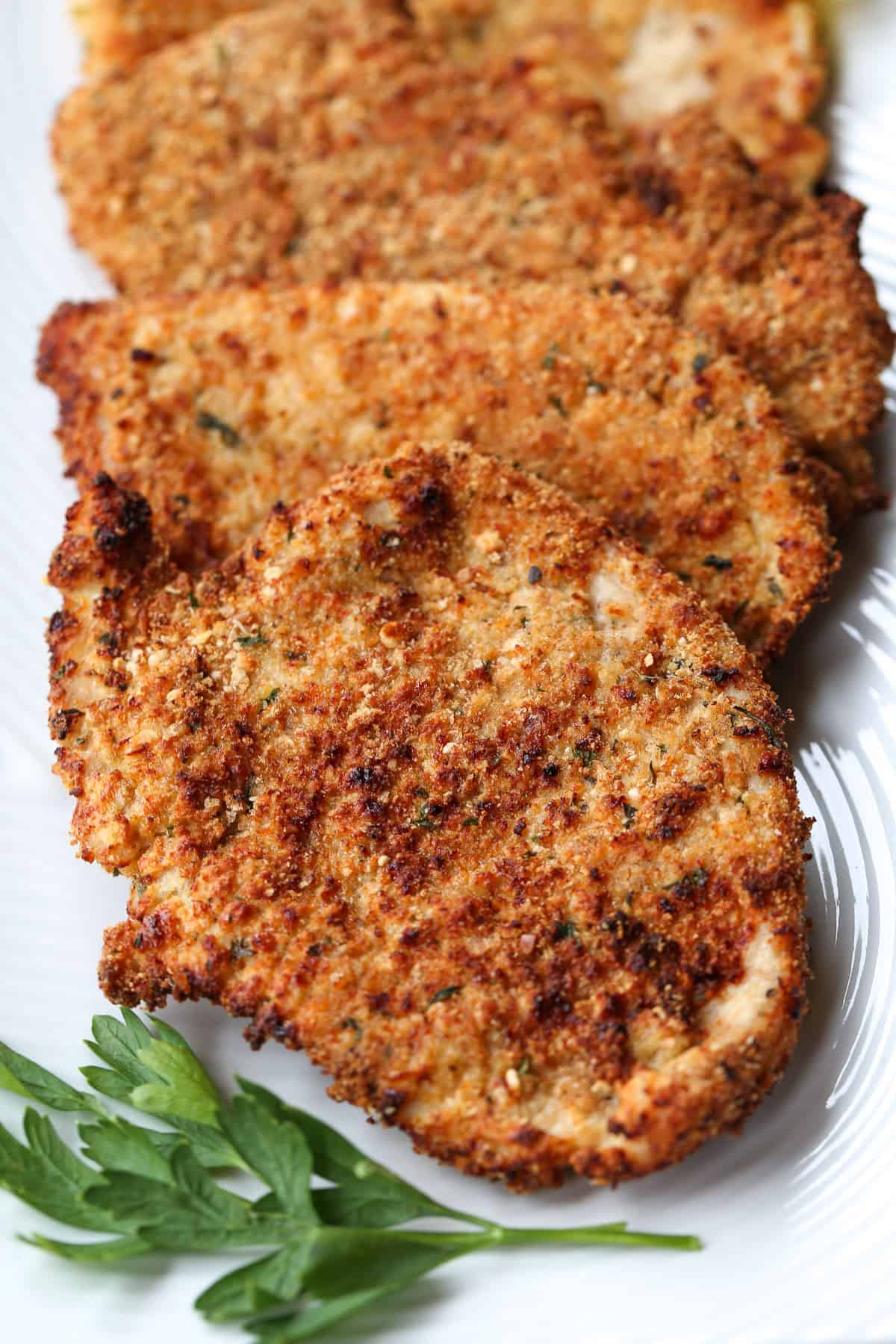 Turkey Cutlets made three ways! Oven bake, pan fry or in the air fryer, they turn out super crispy and tasty any way you make them! turkey cutlets on a platter with parsley