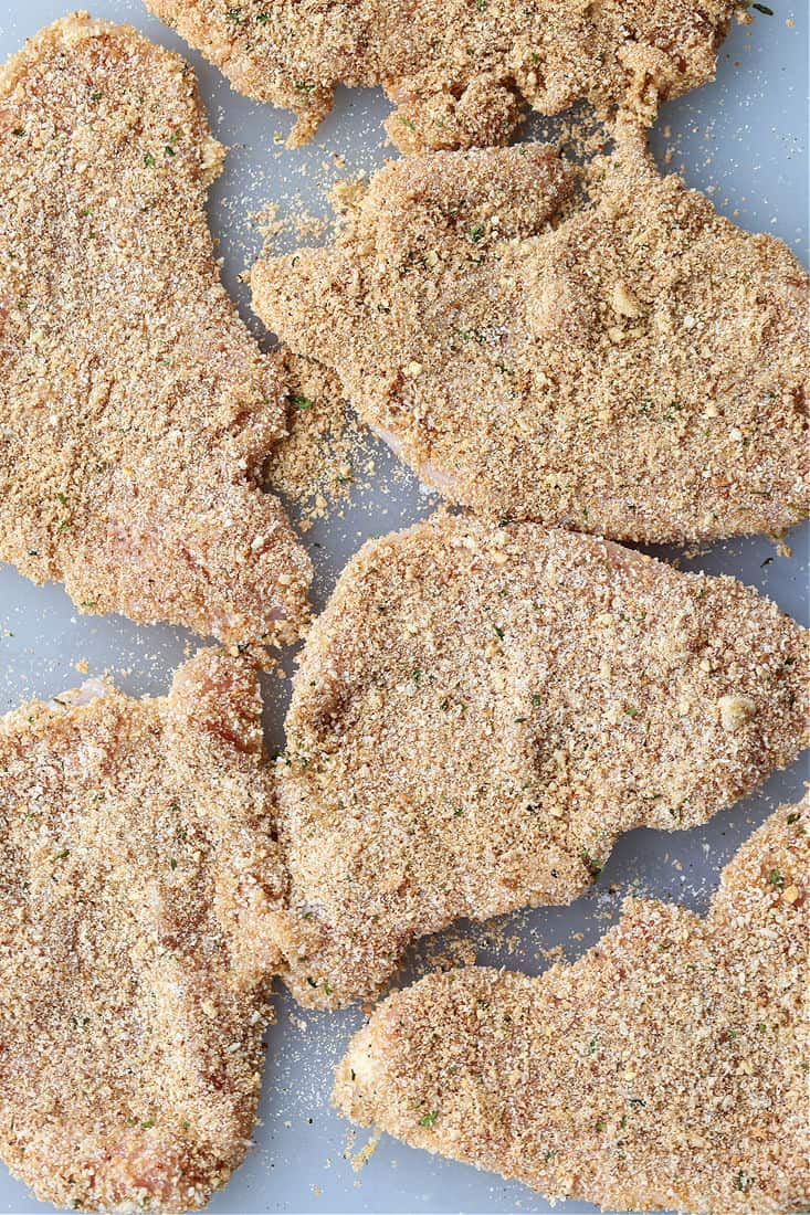 Breaded turkey cutlets on a cutting board