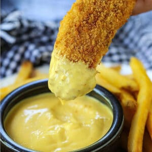 Chicken Fingers dipping into honey mustard sauce