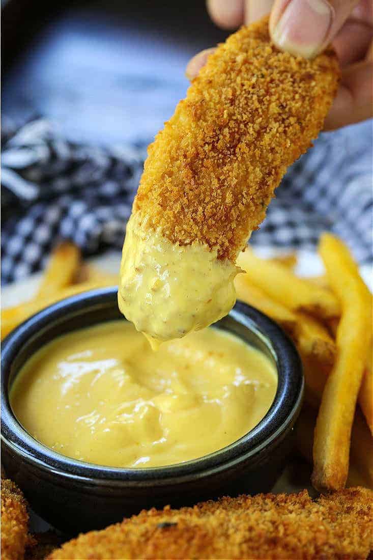 Chicken Fingers dipping into honey mustard sauce