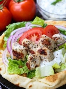 chicken souvlaki on pita bread with tomatoes, onions and tzatzikki sauce