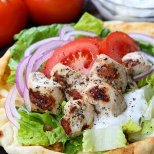 chicken souvlaki on pita bread with tomatoes, onions and tzatzikki sauce