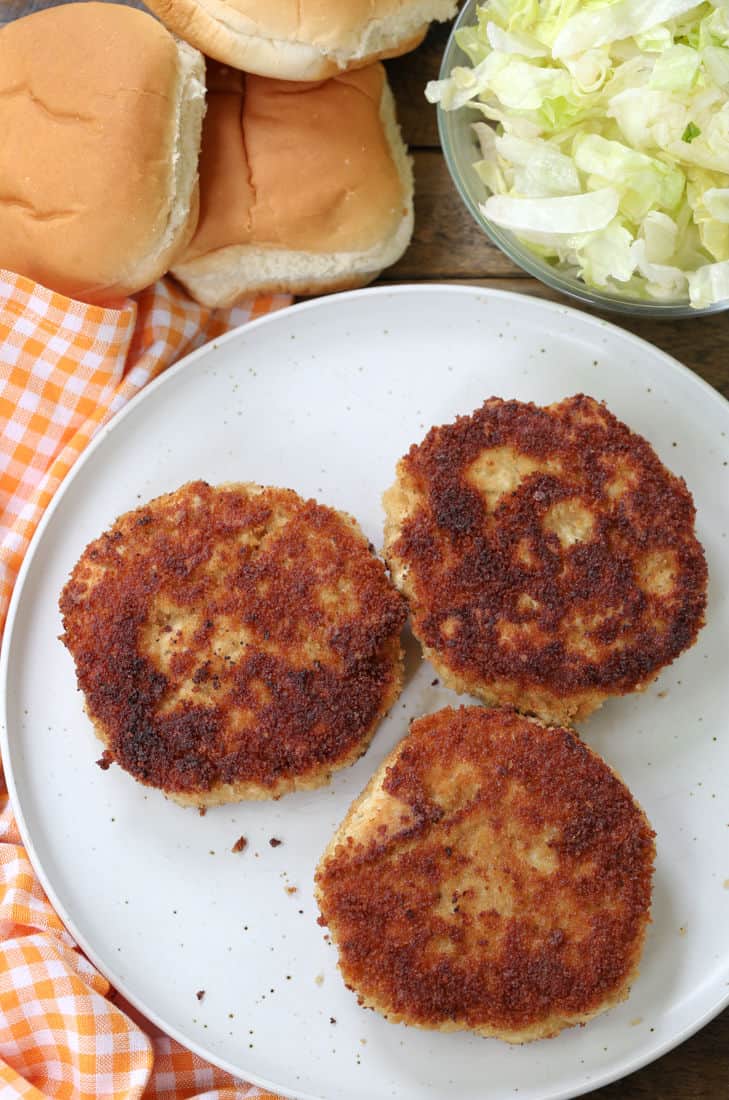 Chicken patties on a plate with buns and lettuce