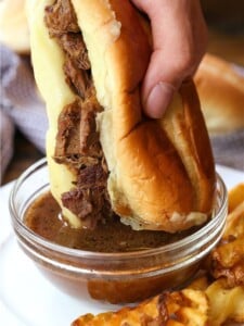 french dip sandwich dipping in au jus
