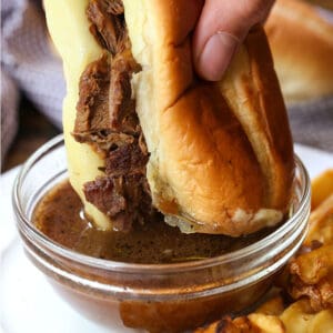 French Dip Sandwich dipping into au jus gravy