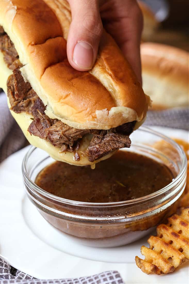 French Dip Sandwich dipping into au jus