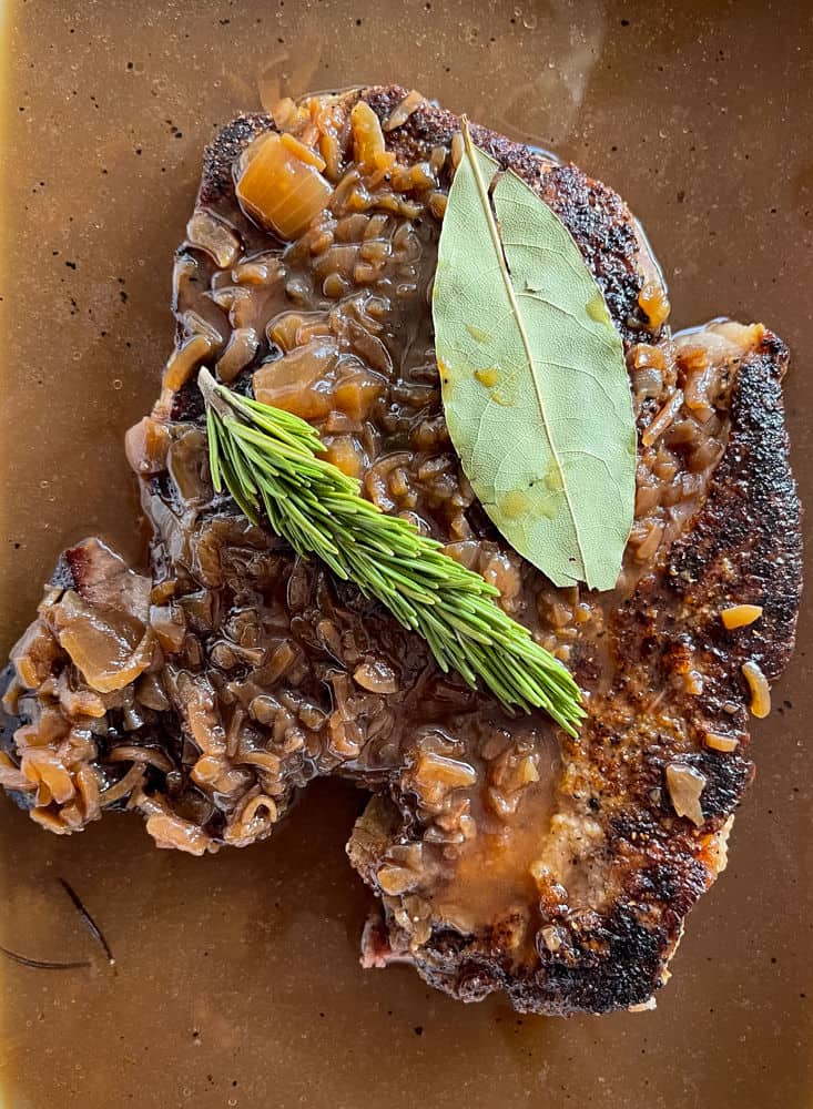 Chuck roast, rosemary and bay leaf in gravy for slow cooker beef recipe