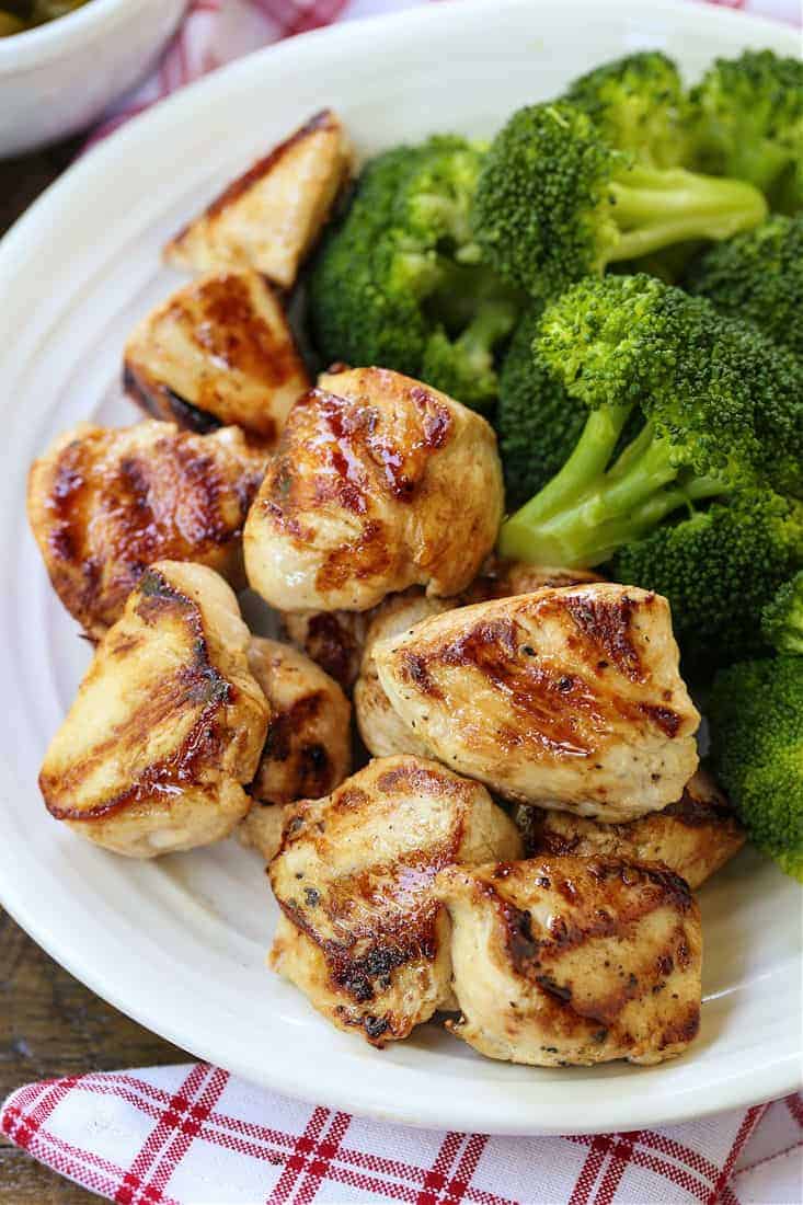 grilled chicken nuggets on a plate with broccoli