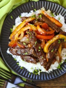 Pepper steak in a black dish with a green napkin