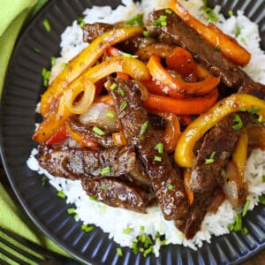 Pepper steak in a black dish with a green napkin