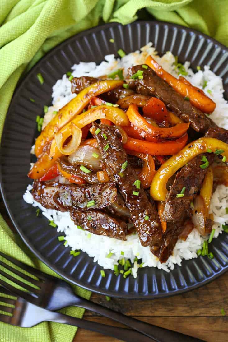 Pepper steak in a black dish with a green napkin