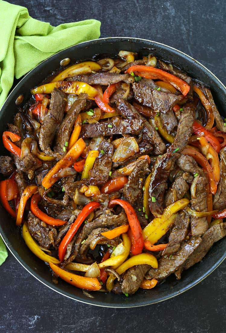 Steak and peppers in skillet with sauce