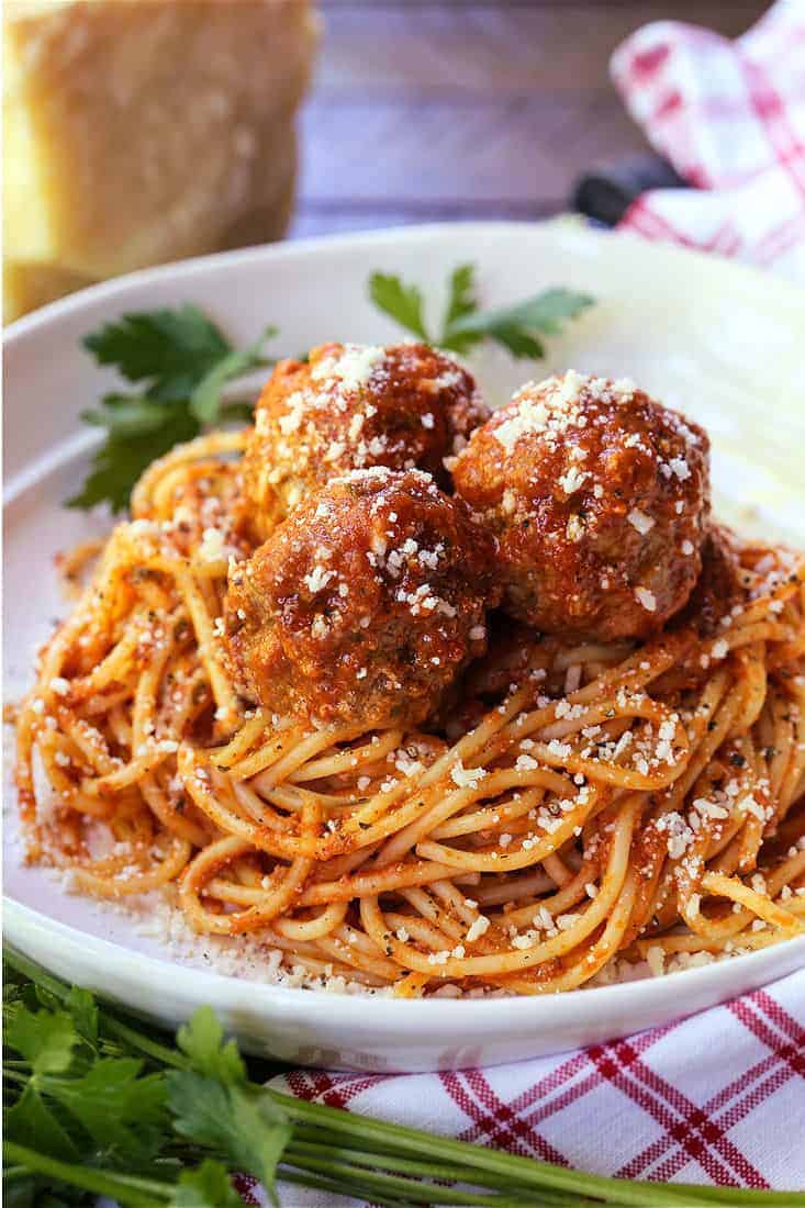 This Slow Cooker Meatballs recipe is the perfect way to have a comfort food dinner even on busy nights! Just cook the pasta and dinner is done! meatballs and sauce recipe served on top of spaghetti