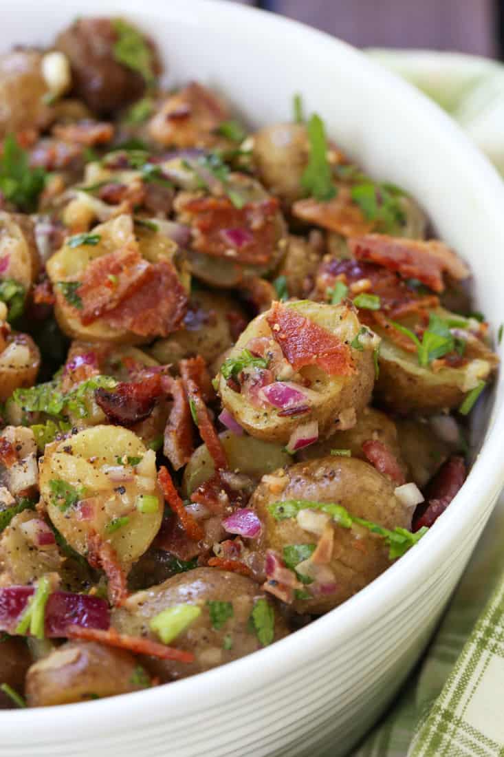 potato salad recipe with bacon dressing in a white bowl