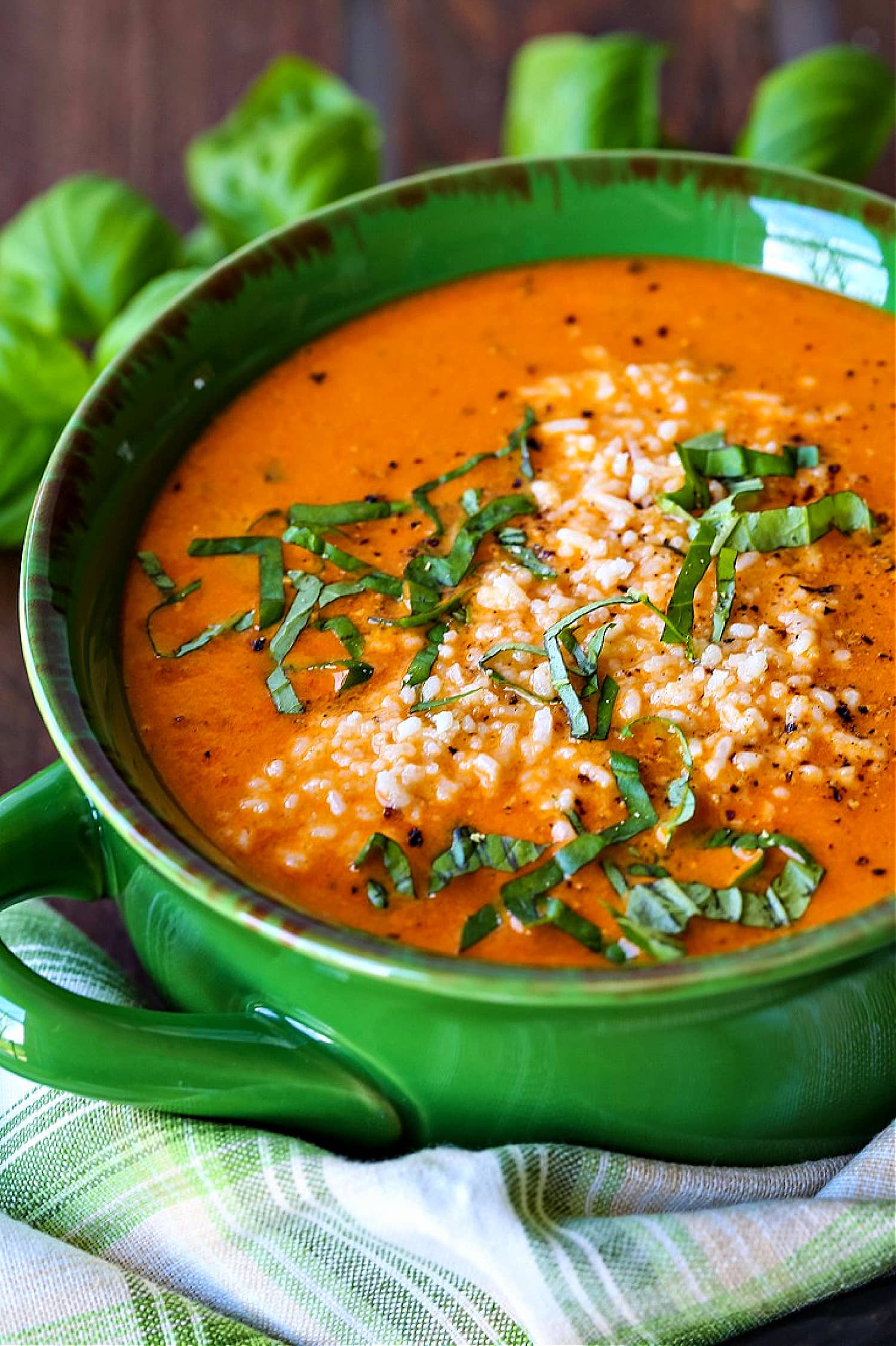 tomato basil soup with parmesan cheese and basil on top