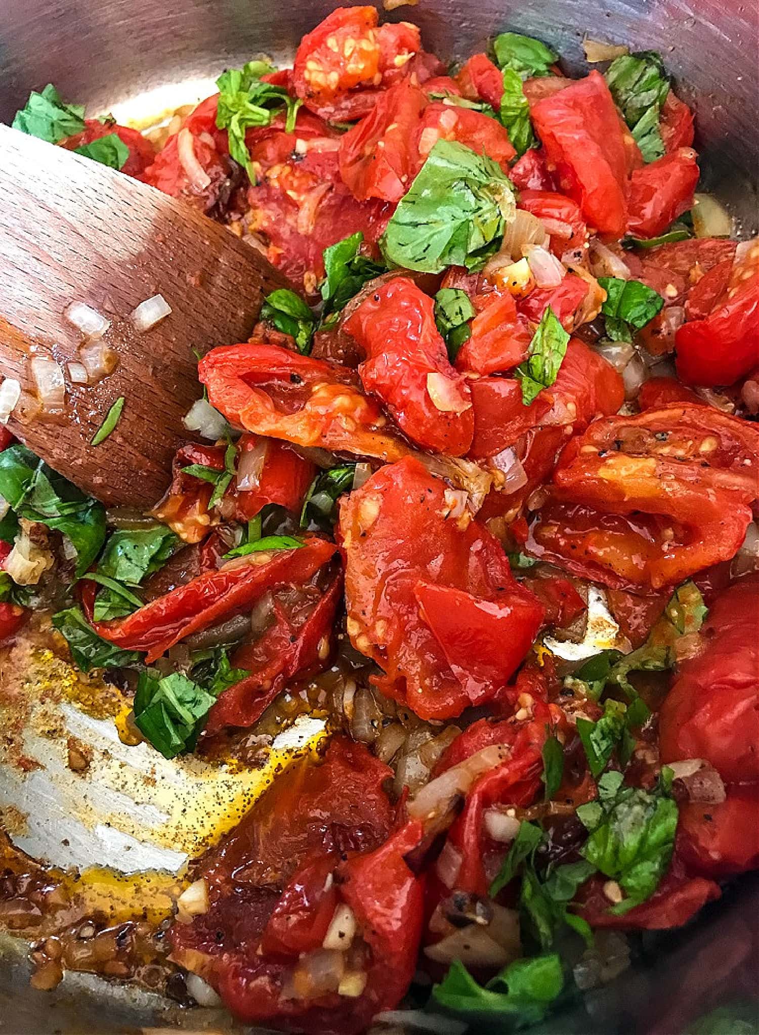 roasted tomatoes, basil and garlic in a pot for soup