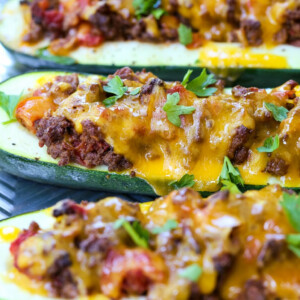 zucchini boats filled with taco filling an topped with cheese
