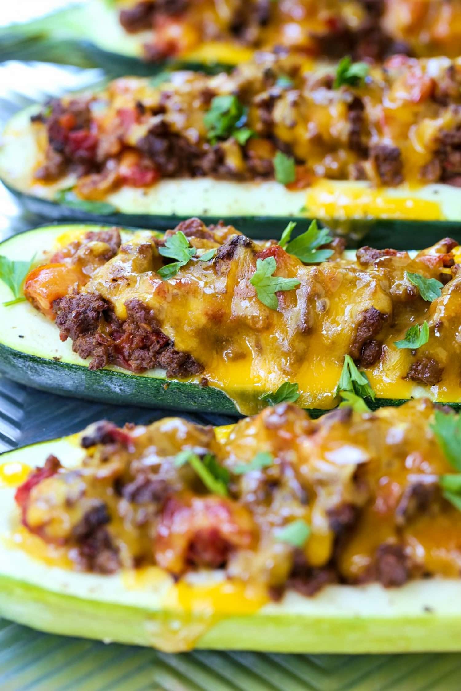 zucchini boats filled with taco filling an topped with cheese
